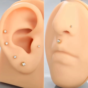 Detail van gouden titanium labret studs met zirkonia op siliconen lichaamsmodellen