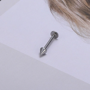 Detailopname van zilveren titanium lipstud met scherpe kegelspike en platte schijfbasis