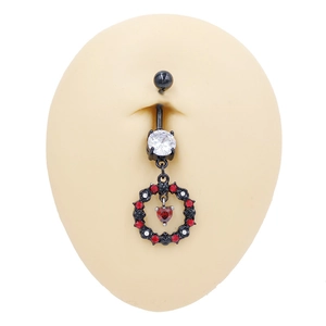 Detalle macro del piercing de ombligo gótico negro con corazón rojo y corona de circonitas
