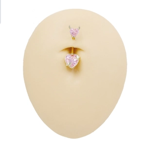 Detailed view of gold belly ring with pink heart zircon on a realistic model