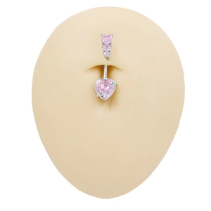 Detailed view of pink heart-shaped zircon navel ring on a silicone belly model