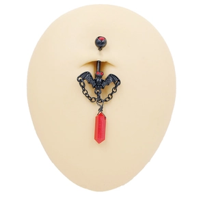 Detalle de piercing de ombligo de murciélago negro con colgante de cristal rojo