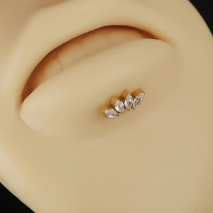 Piercing lèvre en titane doré orné de quatre zircons marquise disposés en éventail chic