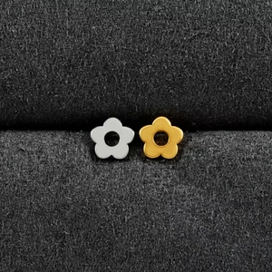 Gros plan de boucles d'oreilles fleurs évidées dorées et argentées sur un fond velours