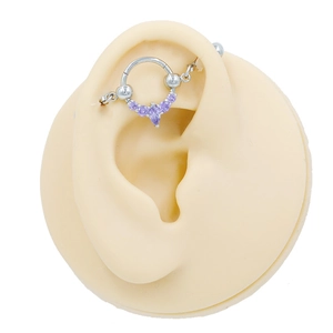 Λεπτομερής προβολή ασημένιου industrial piercing με μωβ πέτρες σε μοντέλο αυτιού