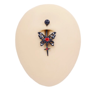 Detailed view of black butterfly navel ring with red heart gem and cross pendant on model
