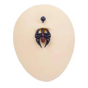 Detailed view of black gothic spider navel piercing with red gemstone on body mold