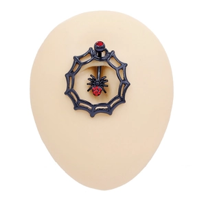 Detail of gothic navel ring featuring a black spider web and red rhinestone accents
