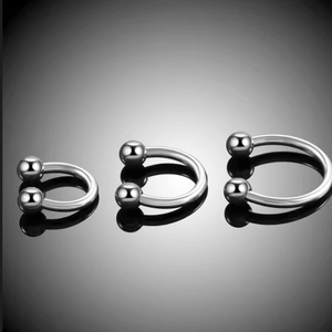 Polished G23 titanium horseshoe rings in three sizes with reflective finish on dark background