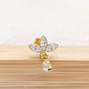 Macro shot of gold G23 titanium lotus ear stud with marquise zircon stones and chain
