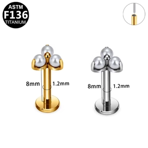 Detail van G23 titanium piercing met wit parelcluster in goud en zilver voor lip en oor