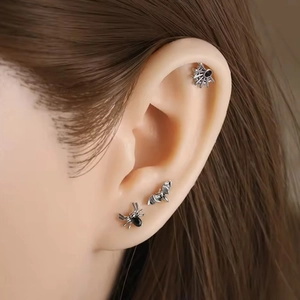 G23 titanium ear piercings set with spider bat and sun shapes on ear cartilage