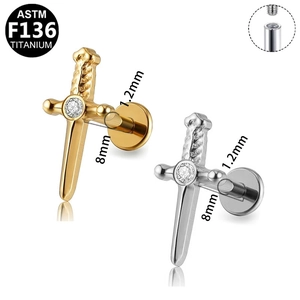 G23 titanium dagger piercing stud with zircon in gold and silver finish on white background