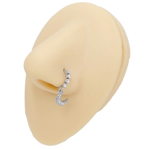 Detail of silver crescent moon nose ring with white zircon studs on a model nose