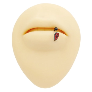 Macro di piercing gotico con ciondolo a bara rossa su stampo in silicone color carne