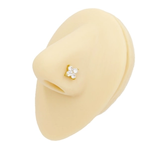 Detail of golden flower nose stud with four clear zircons on a model silicone nose