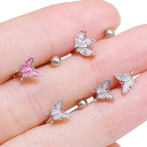 Macro detail of butterfly labret studs with pink glitter and marquise zircon leaf inlay