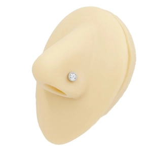 Close-up of a silver stainless steel nose stud with a clear zircon on a nose model