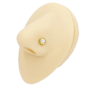 Detailed view of a gold-plated stainless steel nose stud with a clear zircon and bead border