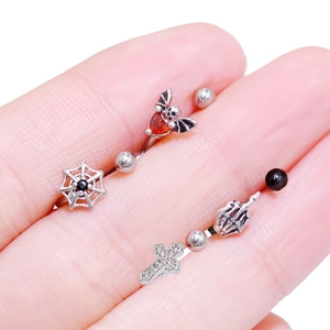 Macro di piercing all'ombelico gotici con ragnatela e teschio tenuti in mano