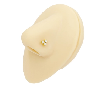 Detail of a gold-plated stainless steel nose stud with three triangle-set round zircons