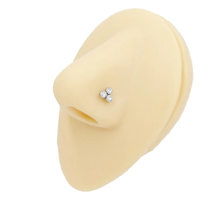 Close-up of triple-zircon butterfly nose stud on silicone model for realistic piercing look