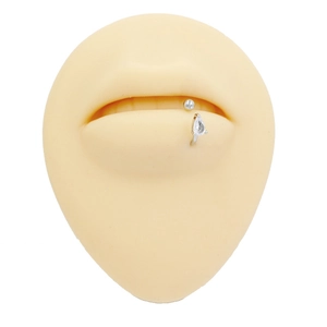 Detailed view of titanium labret with pear-cut zircon on silicone lip model