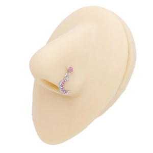Dettaglio di un piercing al naso in argento con zircone rosa e ciondolo a forma di luna