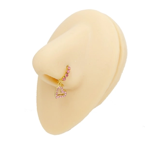 Dettaglio ravvicinato di un anello al naso a cuore dorato con strass rosa su silicone