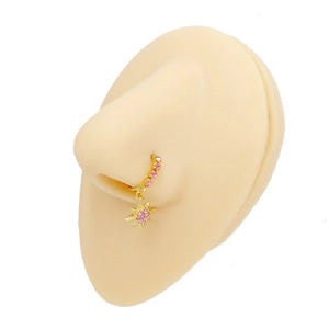 Dettaglio di un anello al naso a stella dorata con strass rosa su un modello in silicone
