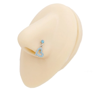 Dettaglio del piercing al naso d'argento con ciondolo a cuore e strass blu chiaro