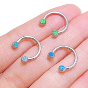 Three horseshoe barbells with green and blue synthetic opals shown on palm for scale