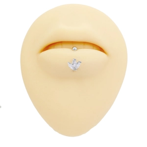 Macro detail of vertical labret jewelry with marquise zirconia on a silicone lip model