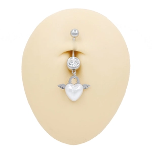 Detalle del piercing de ombligo con forma de corazón y alas en un modelo de silicona