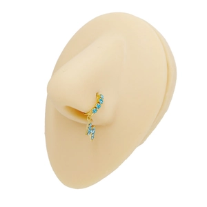 Close-up of golden lightning bolt nose ring with blue rhinestones on a silicone model