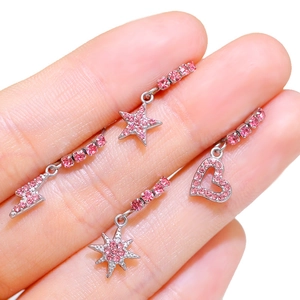 Orecchini in acciaio con cristalli rosa a forma di cuore e stella in mano