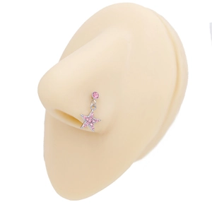 Dettaglio ravvicinato di un piercing al naso d'argento con stella rosa su modella