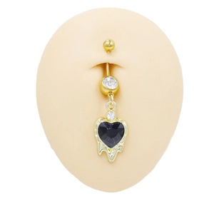 Dettaglio di un piercing all'ombelico a cuore dorato con gemma nera su modello in silicone