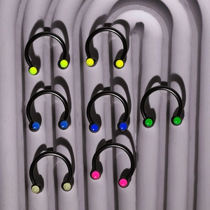 Set of 7 black stainless steel horseshoe body rings with colorful beads on stone board