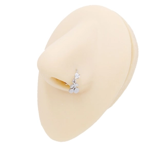 Detail of silver cherry nose ring with clear zircon on a realistic nose model