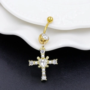 Macro detail of golden cross belly ring with heart crystal and white pearls inlay
