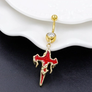 Detail of gold cross belly ring with red enamel and sparkling zircon gemstone inlay