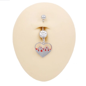 Dettaglio di un piercing all'ombelico a cuore in acciaio con motivo a fiamme rosse su modello