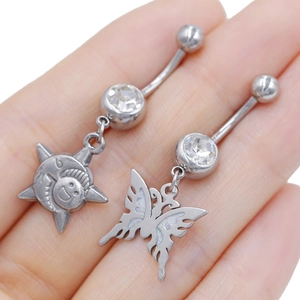Detailed shot of silver belly rings with sun and butterfly charms on a palm for scale