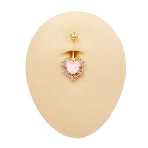 Detailansicht eines herzförmigen Bauchnabelpiercings mit rosa Zirkoniasteinen in Gold