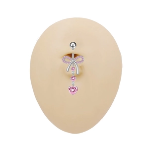 Dettaglio macro di piercing all'ombelico con zircone cuore rosa e fiocco su silicone