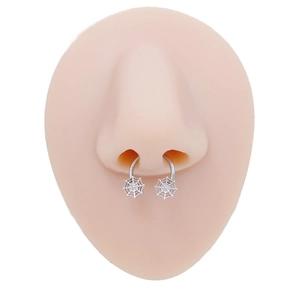 Macro shot of silver spider web nose rings on a realistic silicone nose model