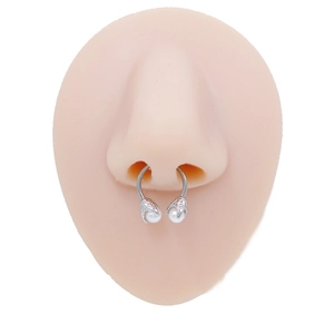 Detail of horseshoe septum ring with eagle claws holding white pearls on silicone model