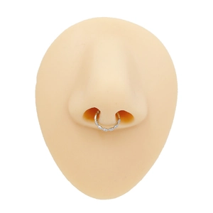 Zilveren roestvrijstalen septumpiercing met textuur op een huidkleurig siliconen neusmodel