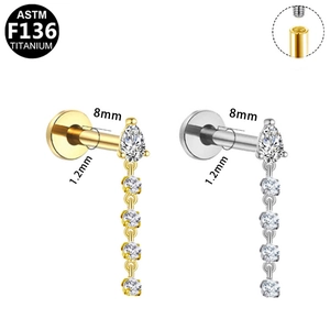 Macro view of F136 titanium labret studs with pear-shaped zircon and dangling chain detail